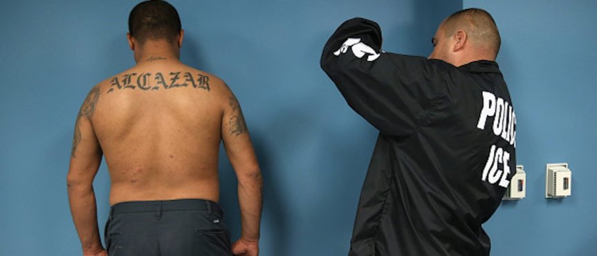 Immigration and Customs Enforcement (ICE), agent photographs a detained immigrant