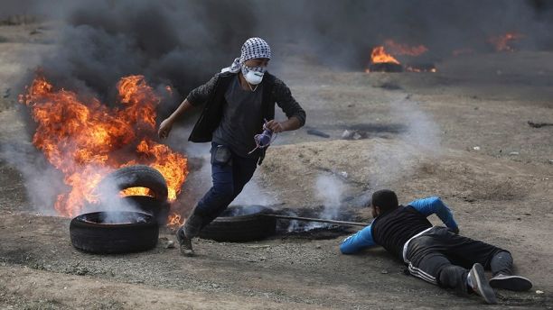 Palestinian protesters burn tires during a protest on the Gaza Strip's