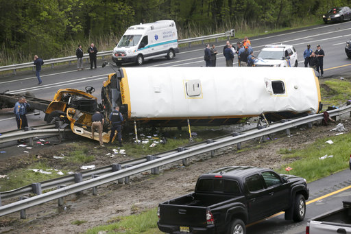 emergency personnel work at the scene of a school bus and dump truck collision
