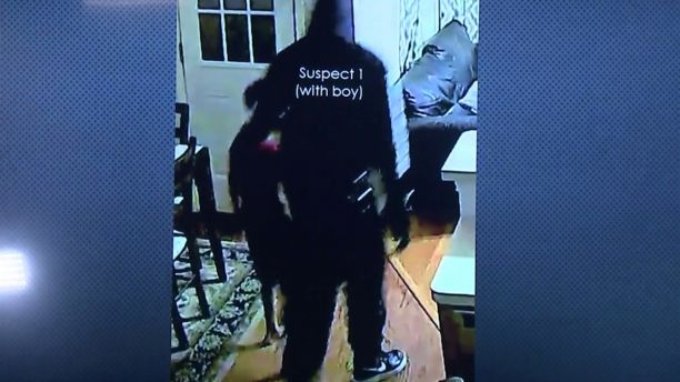 One of the suspects can be seen leading the couple's 7-year-old son around the home looking for money.  (FOX26)