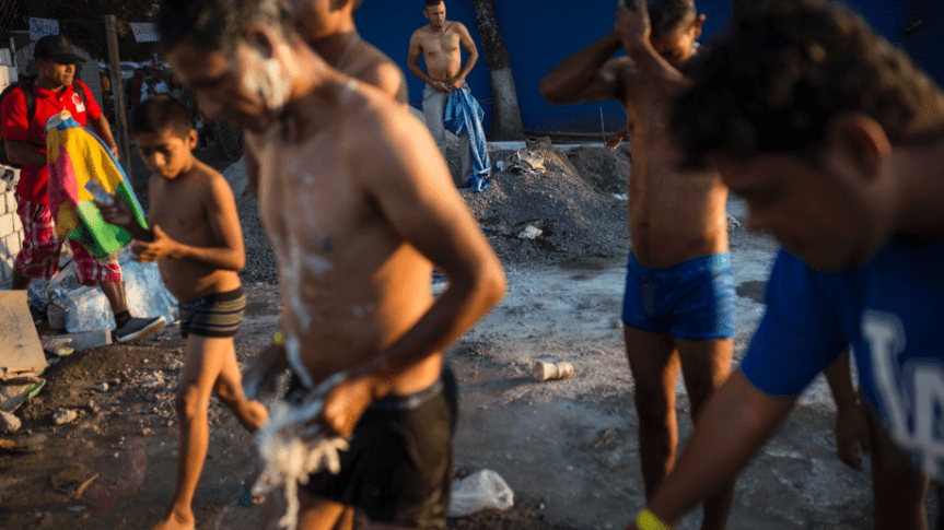Central American migrants shower in a makeshift shelter in Irapuato, Mexico,