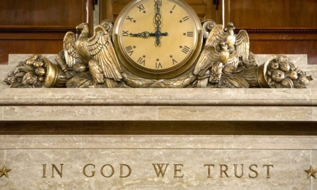 A clock and the motto "In God We Trust"