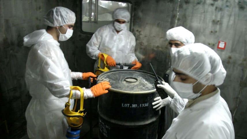 FILE PHOTO: Iranian technicians lift a barrel of "yellow cake"