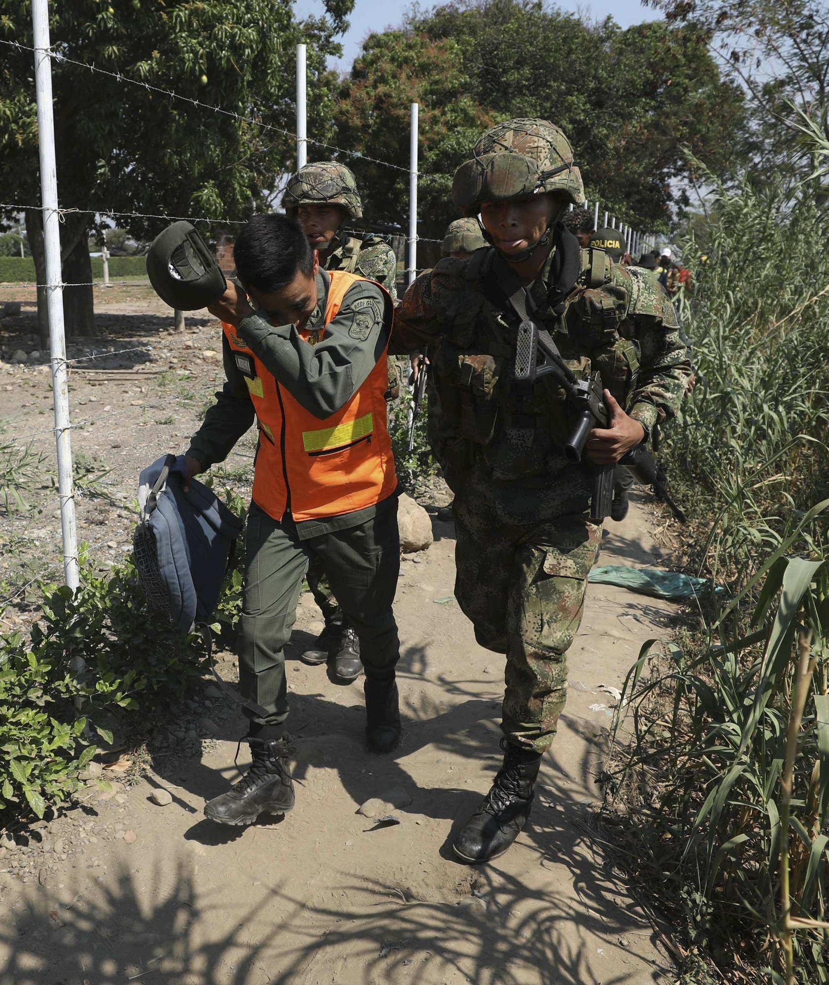 A Colombian soldier escorts a Venezuelan National Guard who deserted his post 