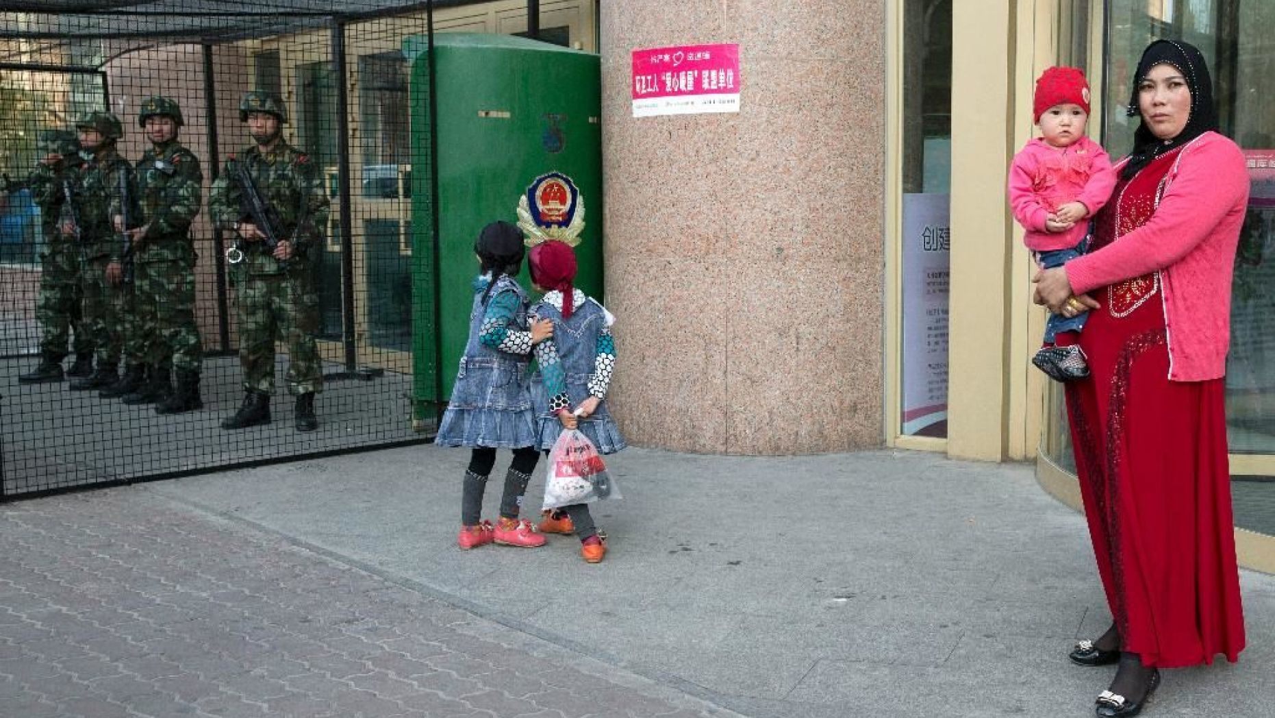 Uighur woman carries a toddler