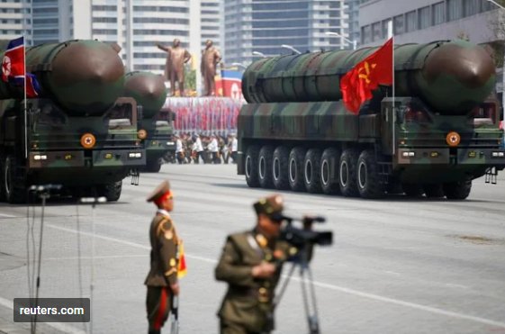 Intercontinental ballistic missiles (ICBM) are driven past the stand with North Korean leader Kim Jong Un