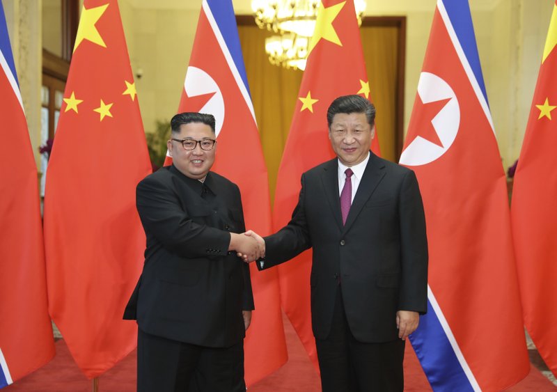 Chinese President Xi Jinping, right, poses with North Korean leader Kim Jong Un
