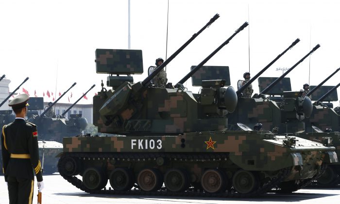 Military vehicles carrying missiles drive past the Tiananmen Gate during a military parade in Beijing