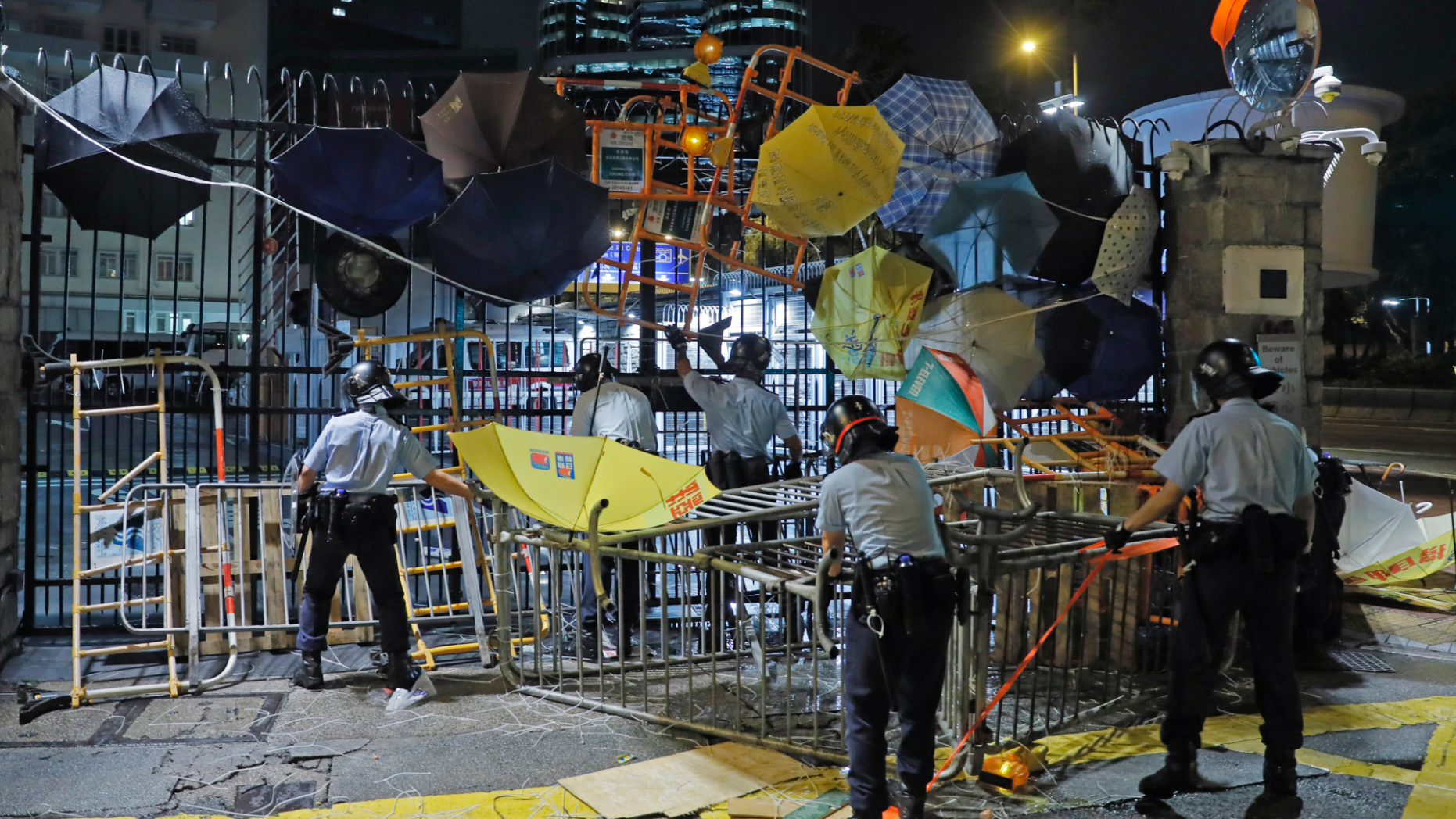 Riot police clear barricades blocked by protesters outside the police headquarters 