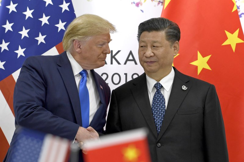 FILE - In this June 29, 2019, file photo, U.S. President Donald Trump, left, shakes hands with Chinese President Xi Jinping during a meeting on the sidelines of the G-20 summit in Osaka, western Japan
