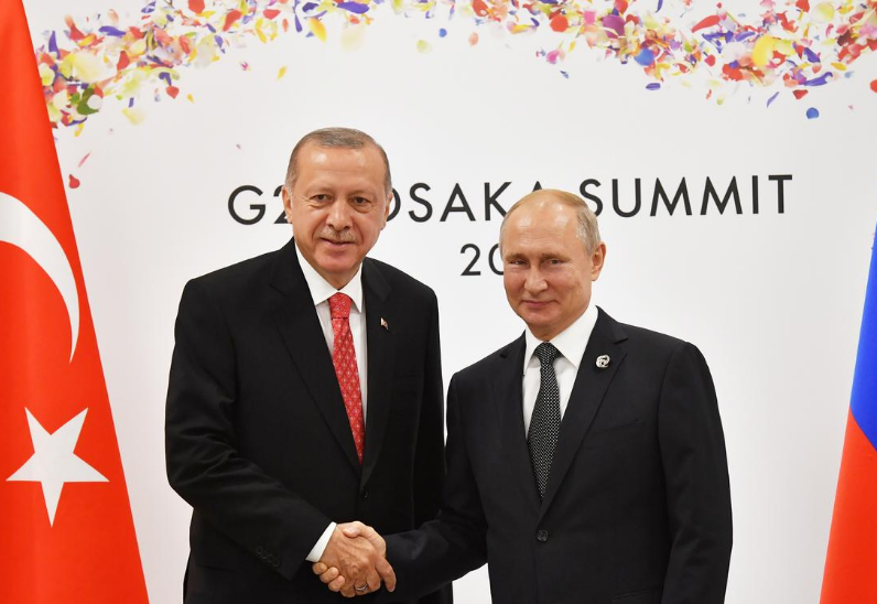 Russian President Vladimir Putin (R) shakes hands with Turkish President Recep Tayyip Erdogan 