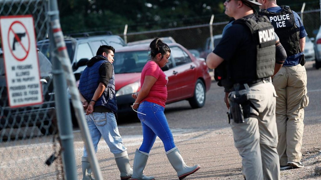 Two people are taken into custody at a Koch Foods Inc. plant in Morton, Miss., Wednesday.