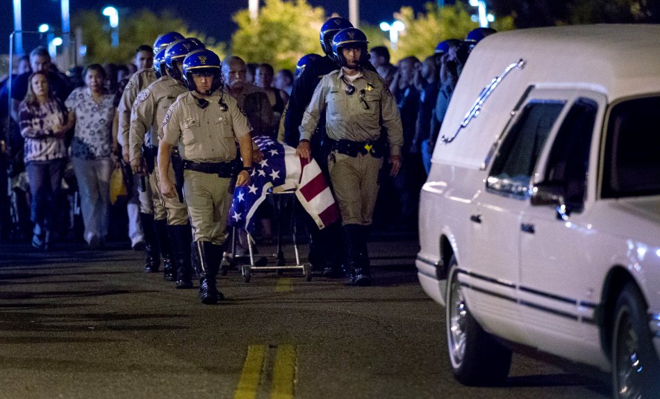 Slain CHP officer Andre Moye is transported to a hearse as his family follows from the Riverside University Health Systems Medical Center after he was shot and killed while two fellow officers were wounded during a traffic stop on the Eastridge Avenue overpass over the 215 Freeway around 5:30 p.m. on Monday, Aug 12, 2019.