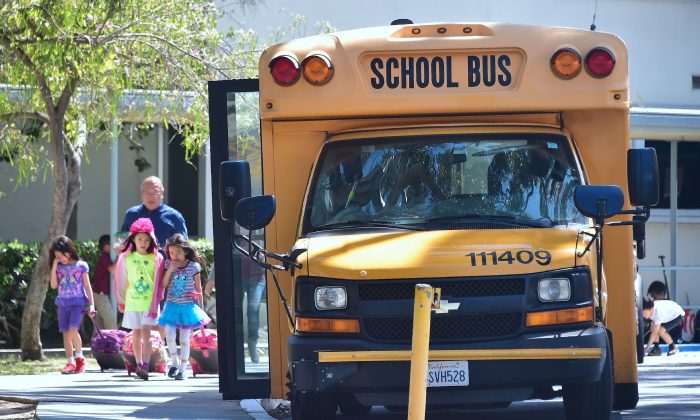 Children walk past a School Bus in Monterey Park, California on April 28, 2017.