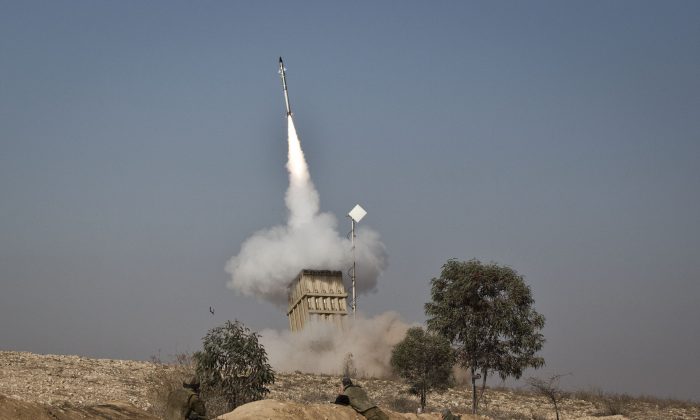 An Israeli soldier lies on the ground as missiles are fired from an Iron Dome anti-missile station near the city of Beer Sheva, Israel on Nov. 15, 2012. 