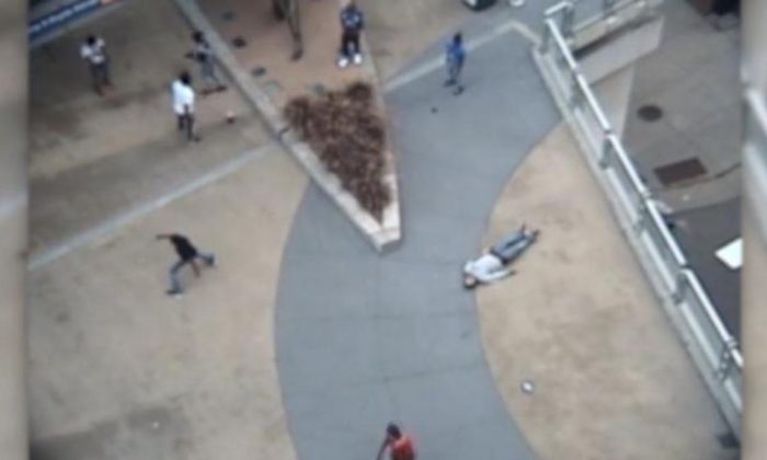 A still-frame from surveillance footage of a violent robbery in which multiple suspects ambushed a man