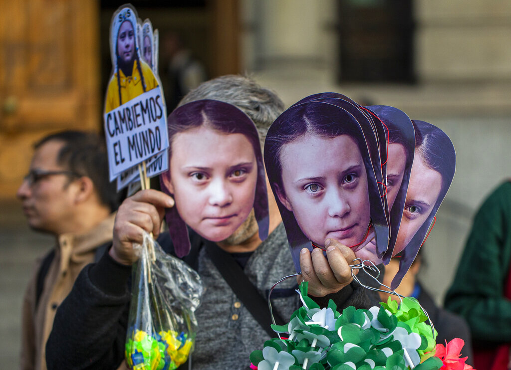 A man sells Greta Thunberg masks during a climate protest rally in Santiago, Chile, Friday, Sept. 27, 2019.