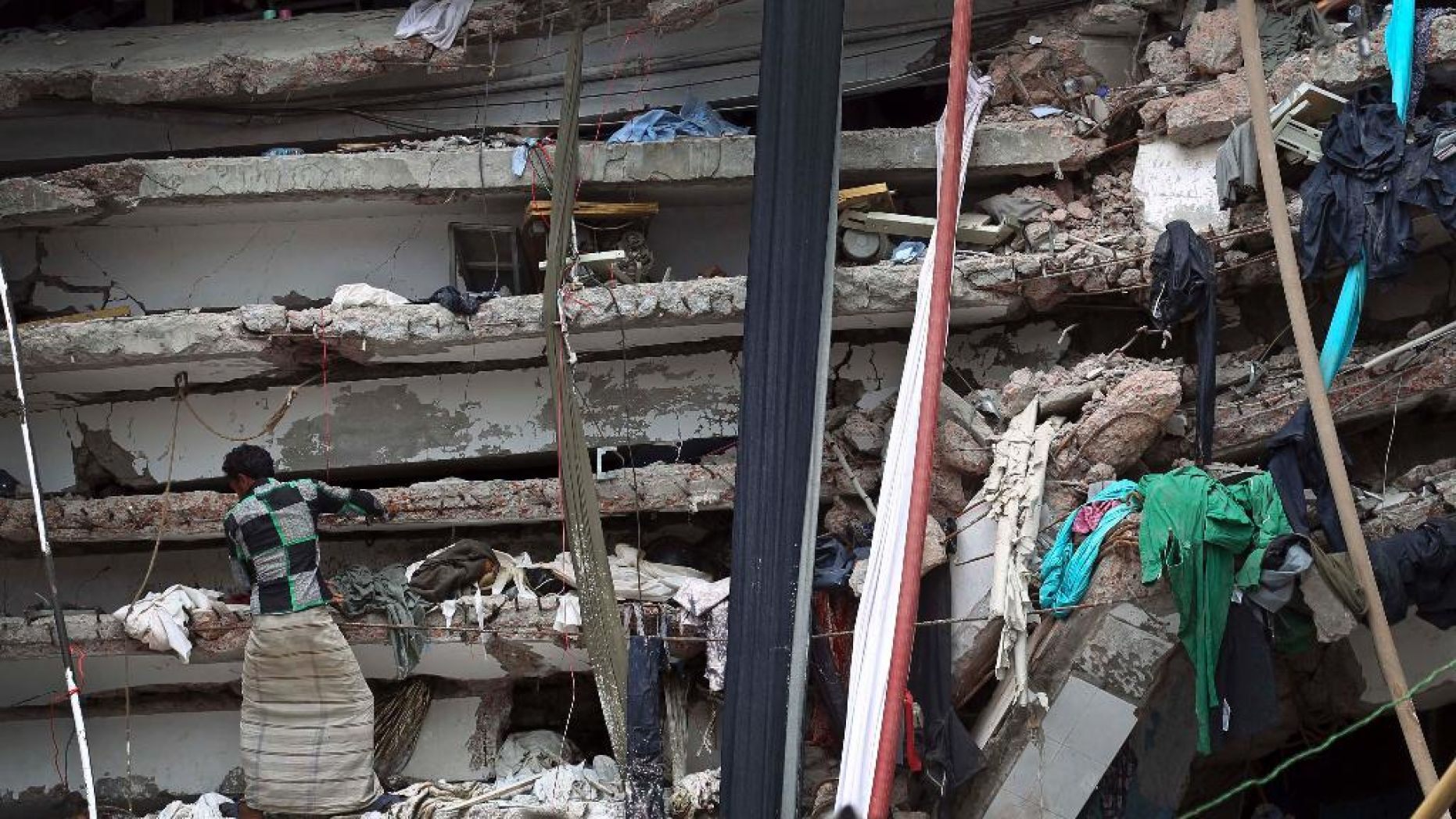 In this April 30, 2013 file photo, a worker toils in a collapsed garment factory building in Savar, near Dhaka, Bangladesh.