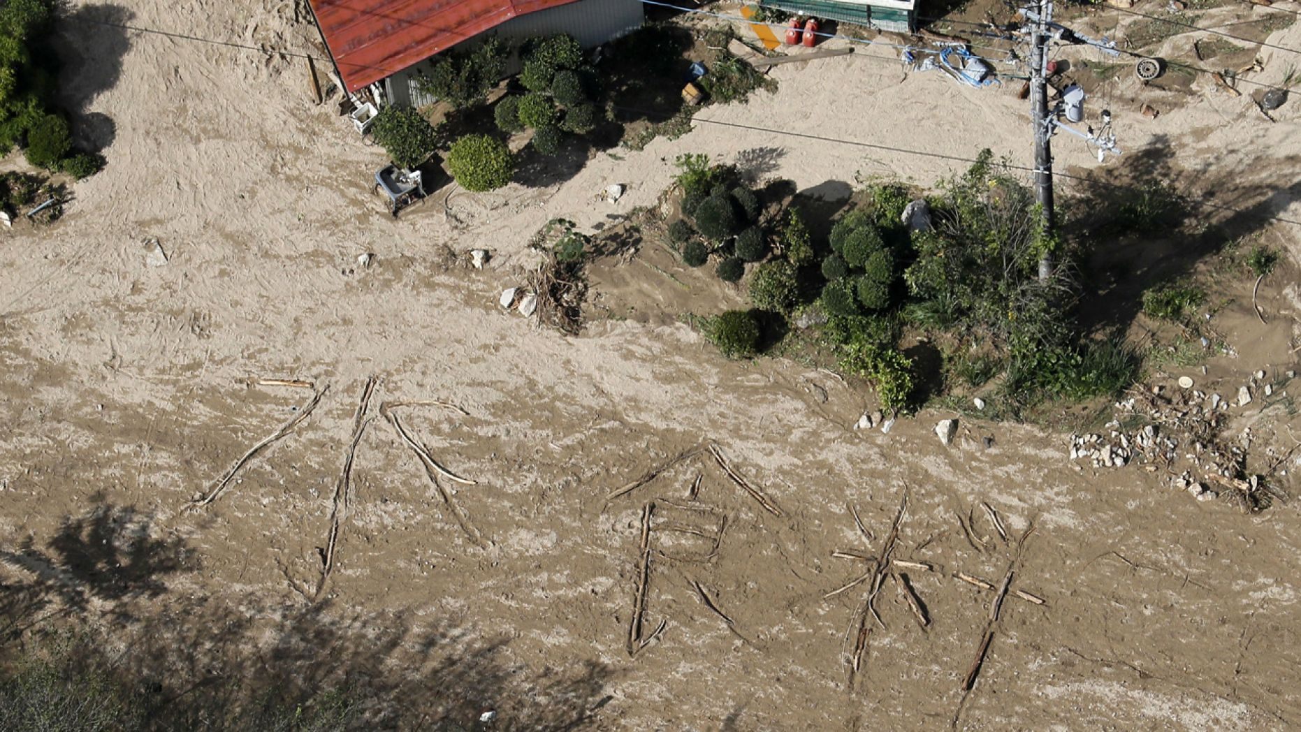The words " Water, Food," are written on the ground in Marumori town, Miyagi prefecture, Japan Tuesday, Oct. 15, 2019.