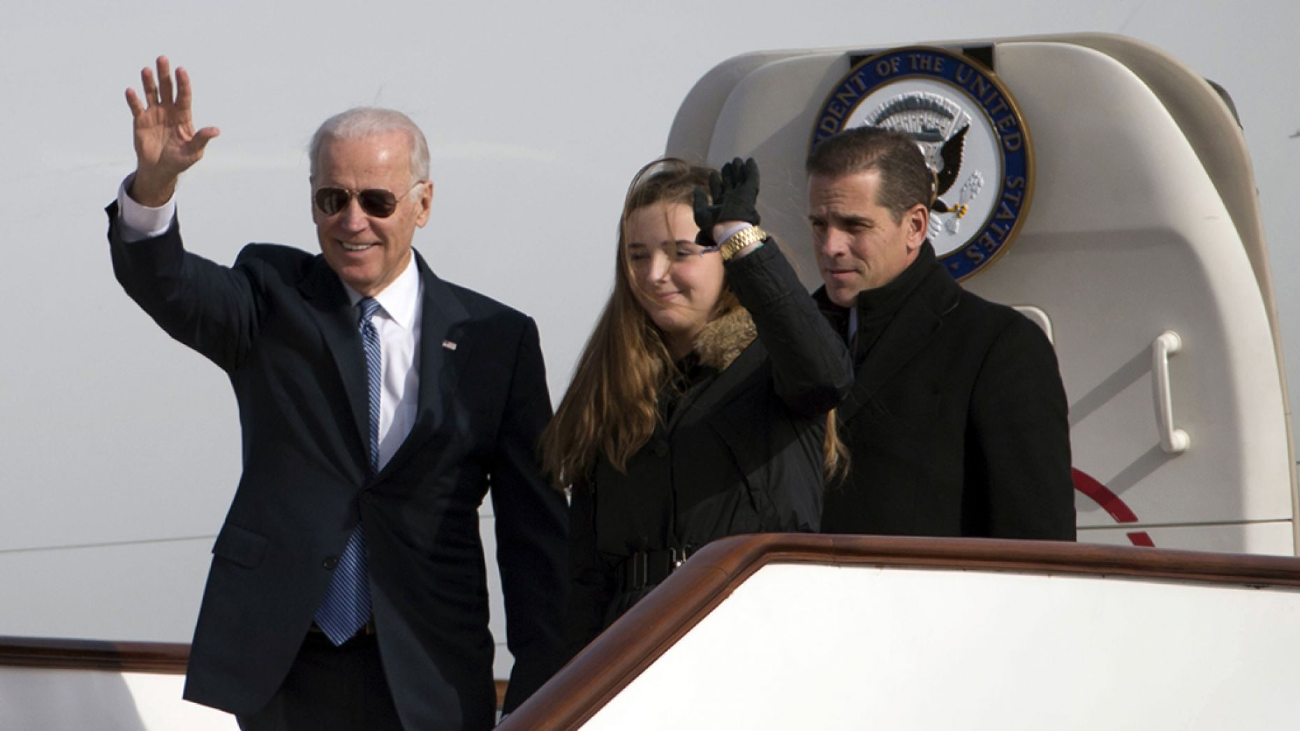 Then-Vice President Joe Biden (L) waves as he walks out of Air Force Two with his granddaughter Finnegan Biden and son Hunter Biden at the airport in Beijing December 4, 2013.  