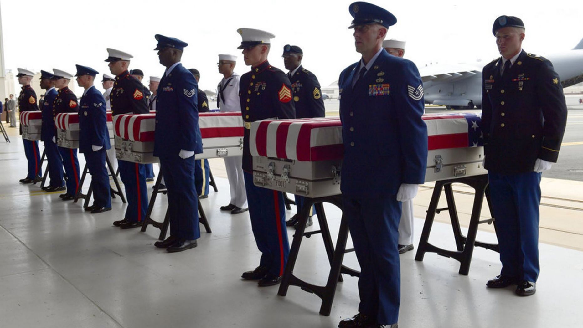 Military members stand at attention after placing transfer cases in a hanger at a ceremony marking the arrival of the remains believed to be of American service members who fell in the Korean War at Joint Base Pearl Harbor-Hickam in Hawaii, in August 2018.
