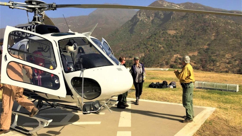 Mrs. Gomez and Helitack team land at Helibase. "S.O.S" spelled out with rocks saved a woman missing in a national park for days