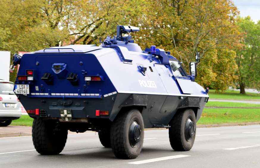 A police tank patrols at a crime scene near a Synagogue.