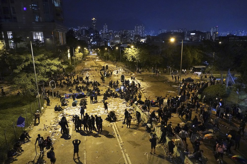 Students use bricks and obstacles to block a main road at the City University campus in Hong Kong, Tuesday, Nov. 12, 2019. Police and protesters battled outside university campuses and several thousand demonstrators blocked roads as they took over a central business district at lunchtime on Tuesday in another day of protest in Hong Kong.