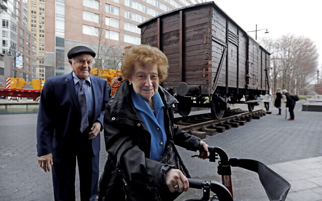 Holocaust survivors Leon Kaner, age 94, and his wife Ray Kaner, age 92, pass a vintage German train car, like those used to transport people to Auschwitz and other death camps, outside the Museum of Jewish Heritage, in New York, March 31, 2019.