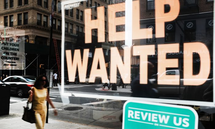 A help wanted sign is displayed in the window of a Brooklyn business in New York on Oct. 5, 2018.