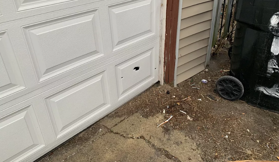 Several bullet holes could be seen in a garage door near the scene of a shooting Monday in the 6200 block of South Mozart Street that left two men dead. 
