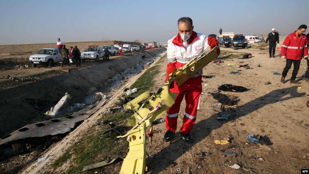 Rescue teams recover debris from a field at the crash site on January 8.