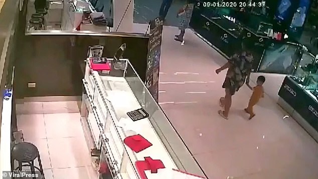 A mother is seen on CCTV holding her two-year-old daughter's hand moments before the crazed gunman opens fire and kills the little girl, a security guard and a young woman.