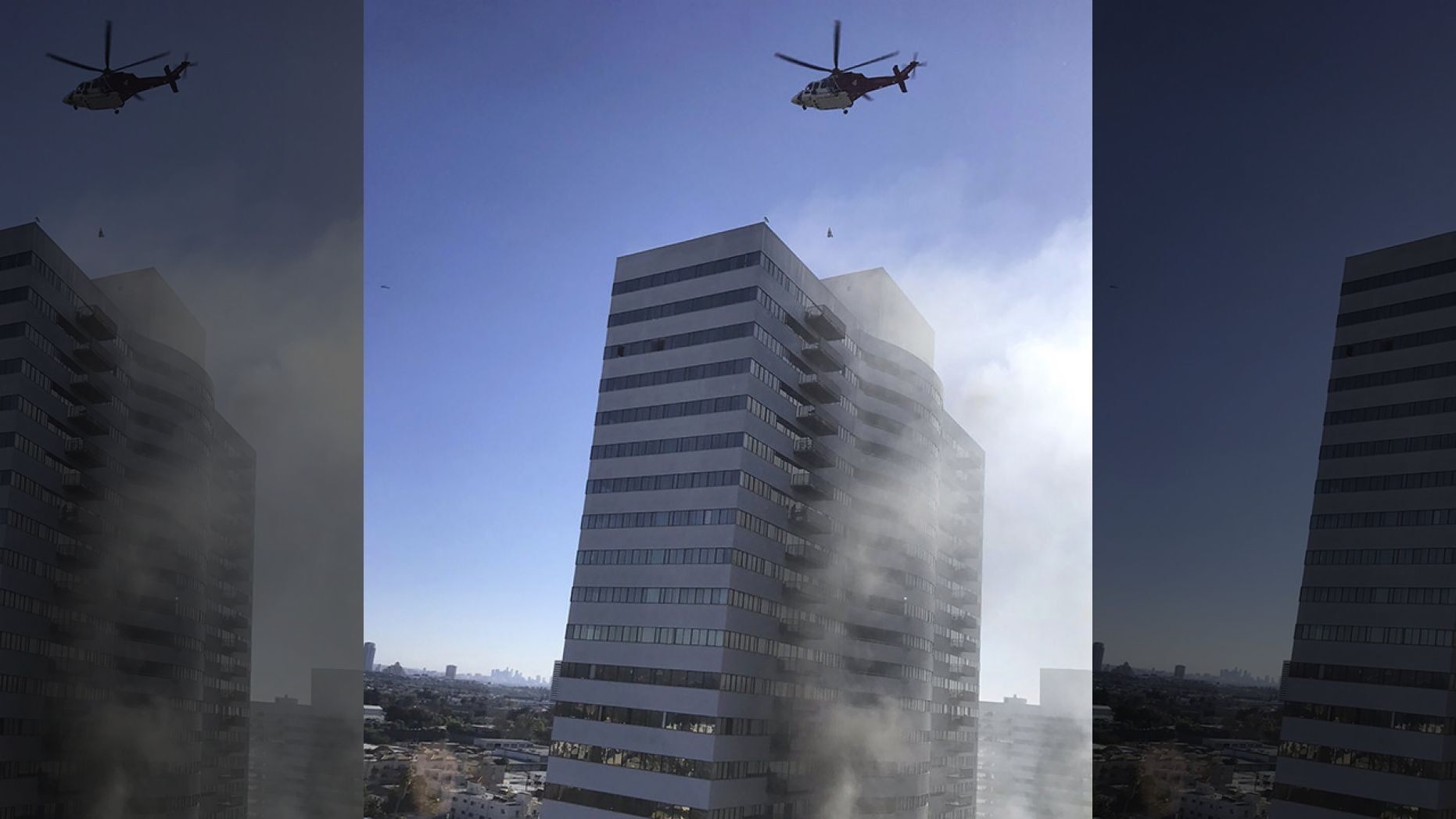 A helicopter flies over a residential building that is on fire in Los Angeles, Wednesday, Jan. 29, 