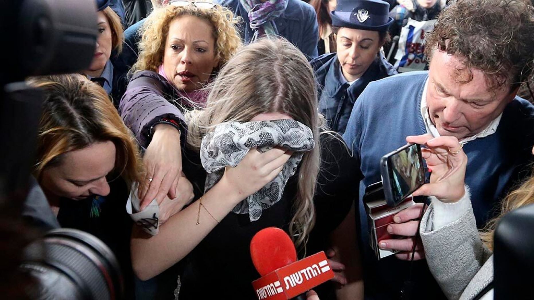 A 19-year-old British woman, center, who was found guilty of making up claims she was raped by up to 12 Israelis arrives at Famagusta District Court for sentencing on Tuesday, Jan. 7, 2020. She insisted she was raped and was coerced by investigators to retract her claim. 
