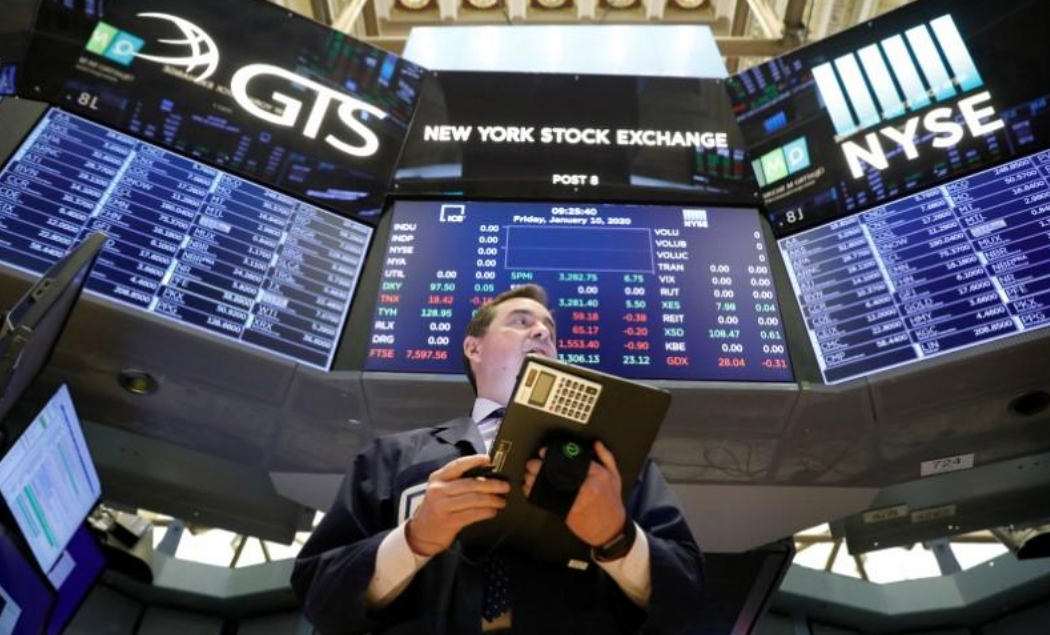 FILE PHOTO: Traders work on the floor at the New York Stock Exchange (NYSE) in New York, U.S., January 10, 2020.