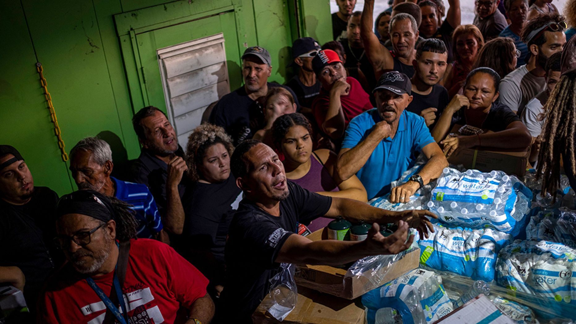 People break into a warehouse with supplies believed to have been from when Hurricane Maria struck the island in 2017 in Ponce, Puerto Rico on Jan. 18, 2020, after a powerful earthquake hit the island.