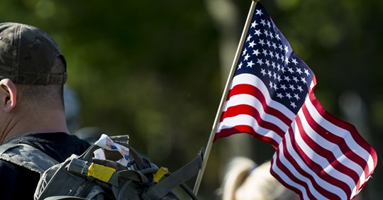 An American flag hangs on the back of a participant during the Chicago Honor the Fallen Ruck March. Approximately 450 military veterans, service members and supporters gathered for a 22-mile ruck march on May 22, just days before Memorial Day, to honor military men and women who suffer from Post-Traumatic Stress Disorder or have committed suicide. (Sgt. 1st Class Michel Sauret/U.S. Army)