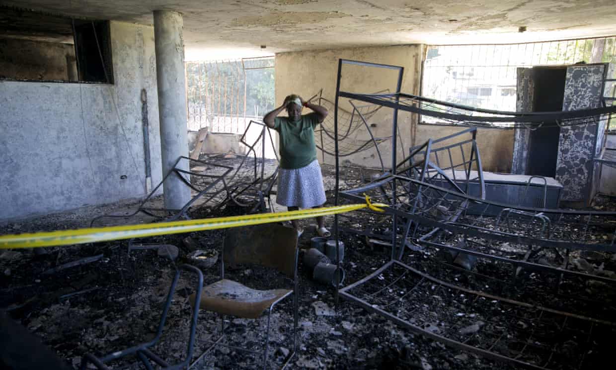A staff worker at the orphanage stands amid the charred children’s home on the outskirts of Port-au-Prince, Haiti, on Friday. Photograph: Dieu Nalio Chery/AP