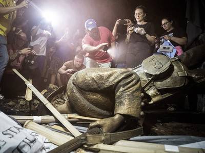 Demonstrators and spectators gather around the toppled Confederate statue known as Silent Sam in August 2018 at UNC-Chapel Hill in North Carolina. A judge has overturned a settlement that the UNC System made with the Sons of Confederate Veterans.