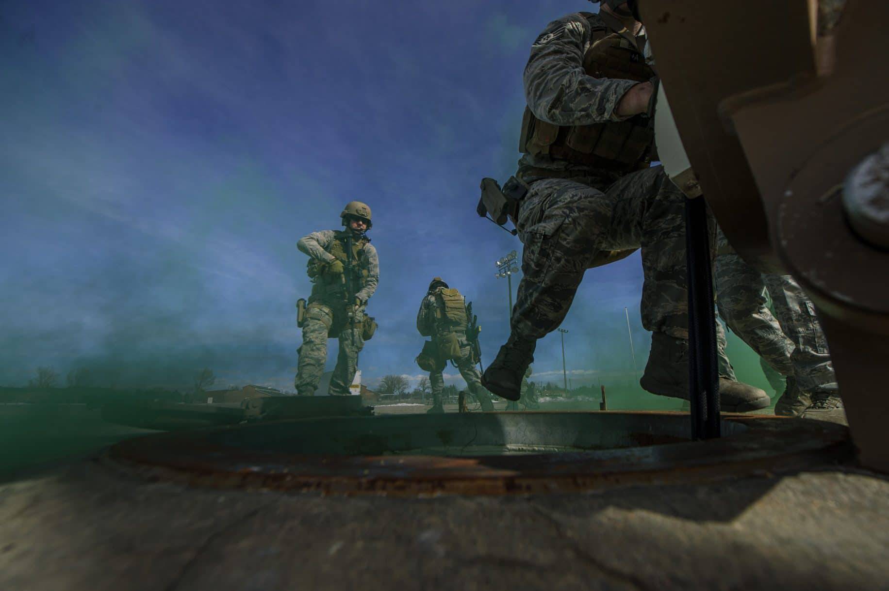 Staff Sgt. Glen Brott rappels down a breached personnel access hatch while Staff Sgt. Scott Shirley provides security during a launch facility recapture exercise Feb. 18, 2014, at F.E. Warren Air Force Base, Wyo.
