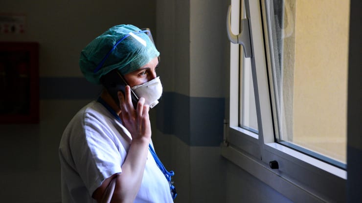 A medical worker wearing a face mask talks on her mobile phone inside the new coronavirus intensive care unit of the Brescia Poliambulanza hospital, Lombardy, on March 17, 2020.