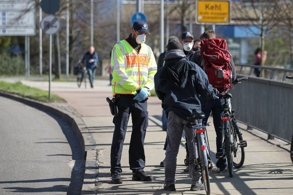 Pictured: German policemen speak to people at the border crossing to France on March 16, 2020 in Kehl, Germany.