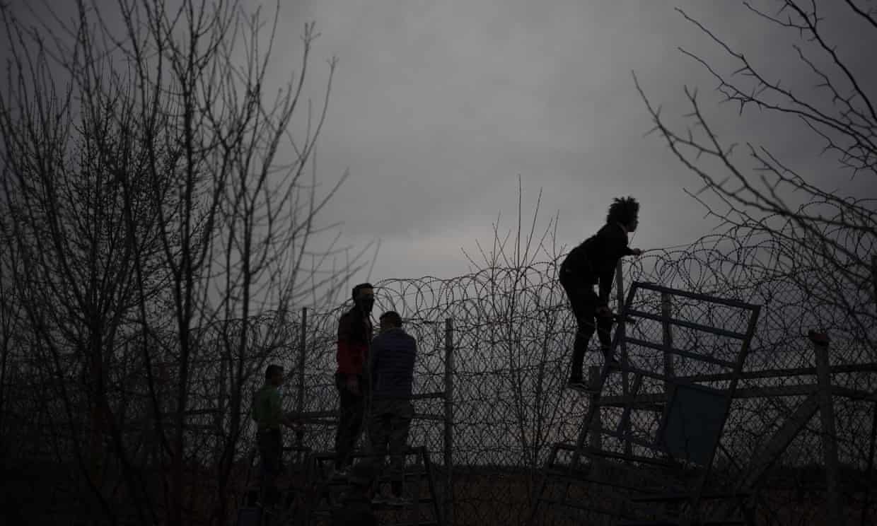 Migrants and refugees attempt to scale the border fence from Turkey into Greece. Photograph: Felipe Dana/AP