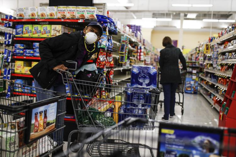A customer browses aisles Friday, March 20, 2020, while wearing a protective face mask at a Stop & Shop supermarket in Teaneck, N.J.