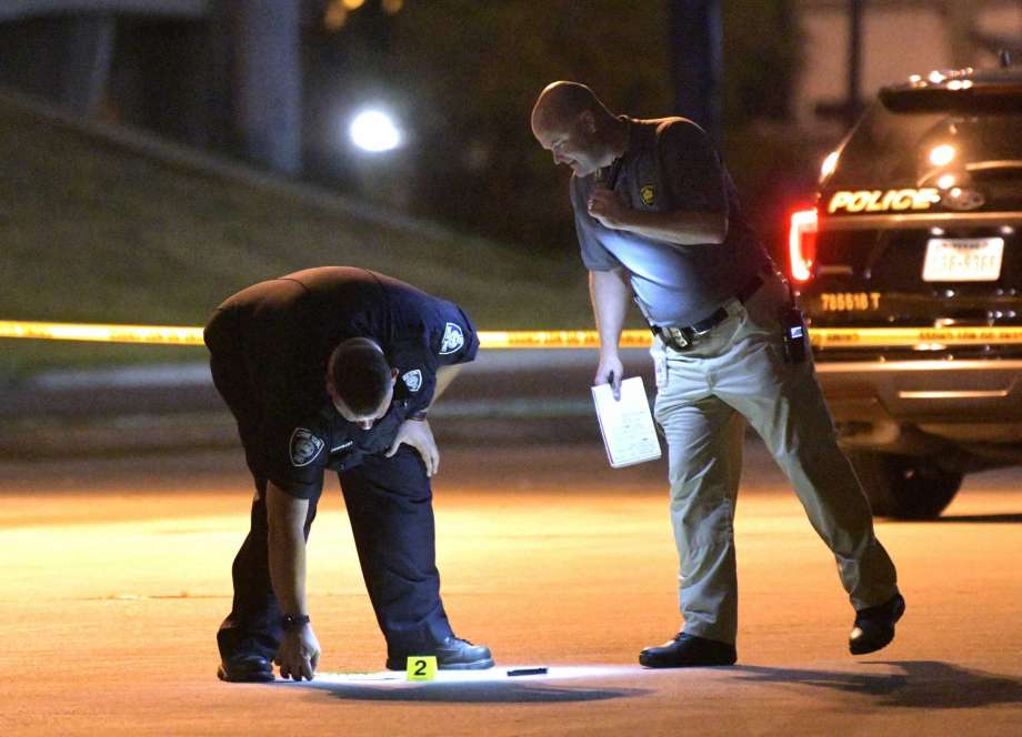 Police look at a machete while they investigate the scene where an officer shot a man