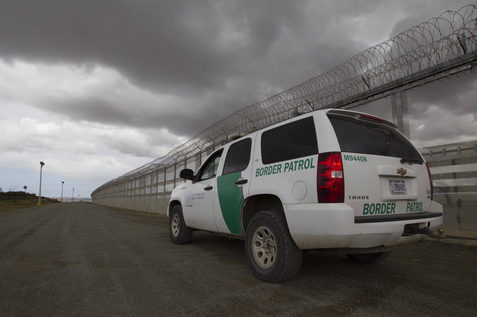 A Border Patrol vehicle sits along the border fenceline separating San Diego and Tijuana Mexico watching for illegal crossings in March 2016. 