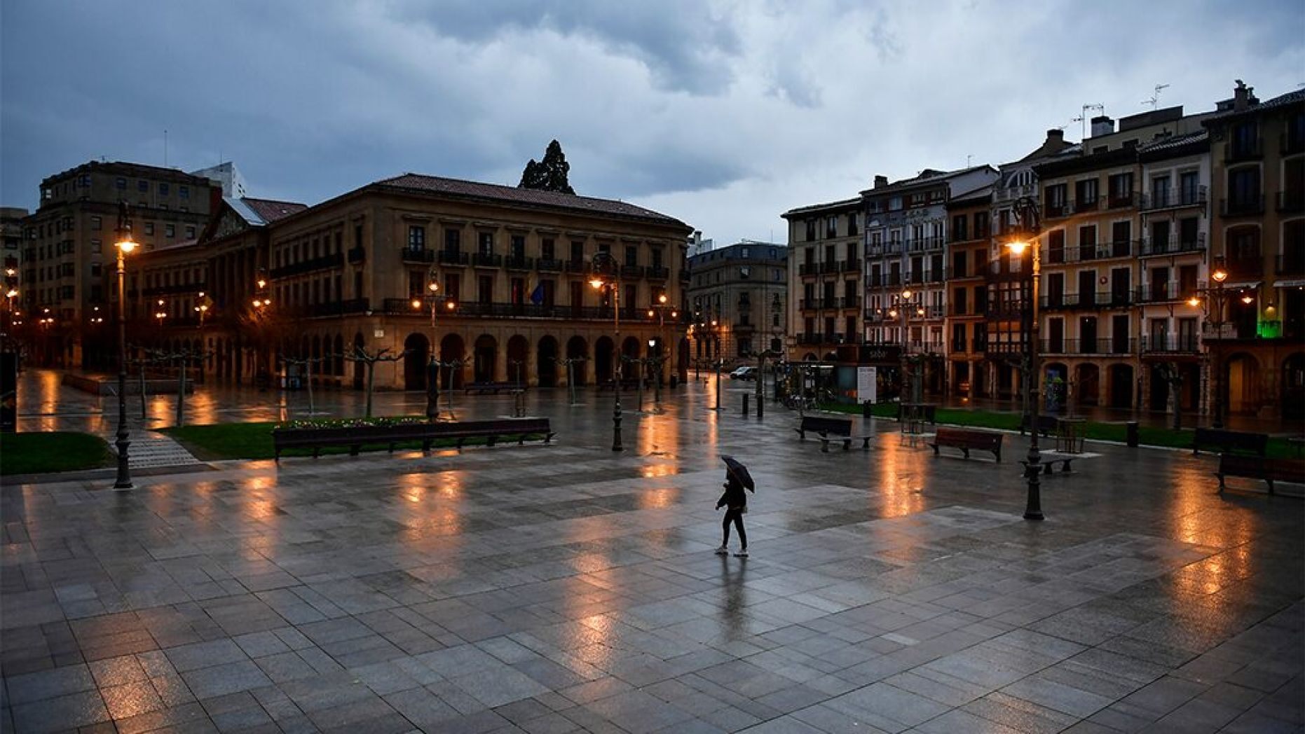 A person walks through an empty Plaza del Castillo square in the old city, in Pamplona, northern Spain, Sunday, March 15, 2020. 