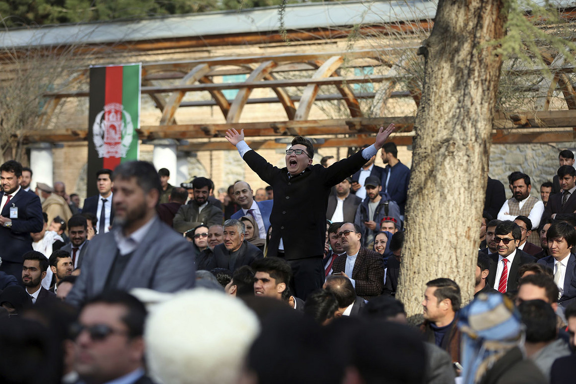 Afghan people chant after a few rockets are fired during inauguration ceremony for Afghan President Ashraf Ghani at the presidential palace in Kabul on Monday. 