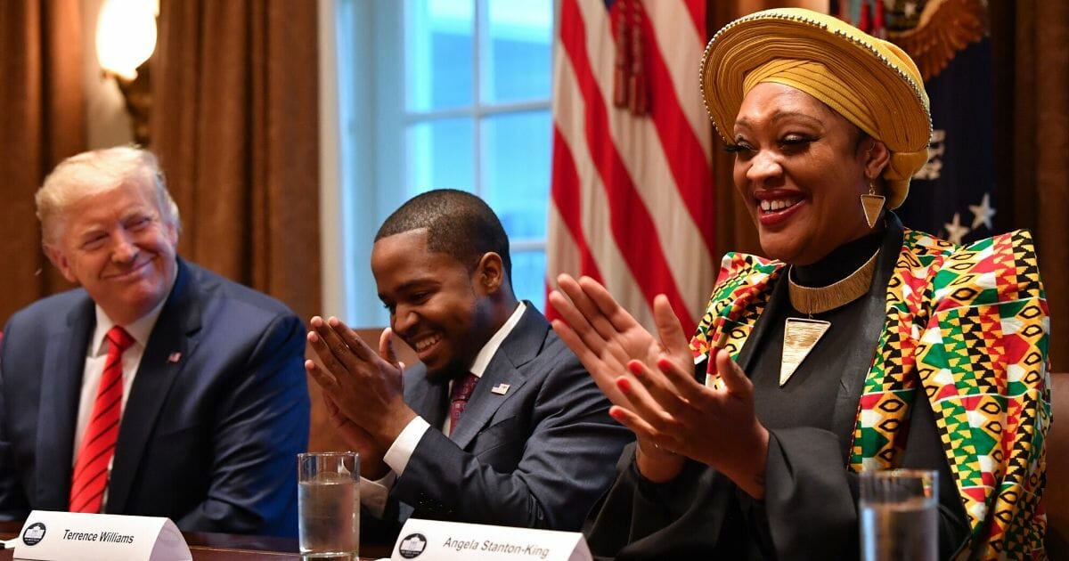 President Donald Trump smiles during a meeting with Terrence Williams, center, Angela Stanton-King, right,